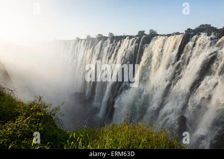 Africa, Zambia, Mosi-Oa-Tunya National Park, l'impostazione di sole illumina la cataratta orientale di Victoria Falls Foto Stock