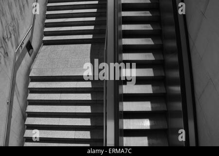 Gradini di scale con corrimano e scale mobili. In bianco e nero. Foto Stock