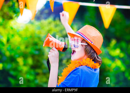 Ragazzo olandese, appassionato di calcio, il tifo e il supporto di squadra di calcio dei Paesi Bassi nel corso del campionato, celebrando la vittoria sportiva Foto Stock