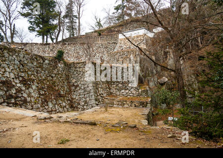 Giappone, Takahashi, Bitchu Matsuyama montagna top castello. Rovina di porta OTE-yaguramon con le mura di Dobei di Uma Yaguruma, torretta, torreggiante sopra. In inverno. Foto Stock