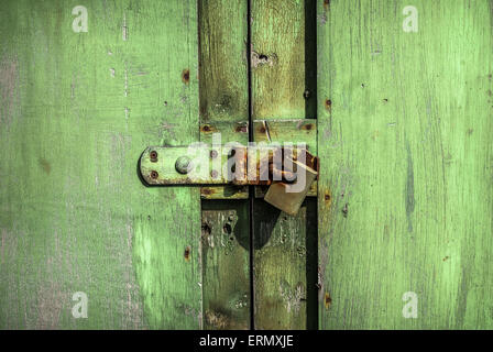 Rusty chiuso con lucchetto della porta verde grunge. Foto Stock