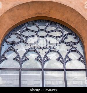 La Chiesa antica finestra ornata con cerchi e fiore Foto Stock