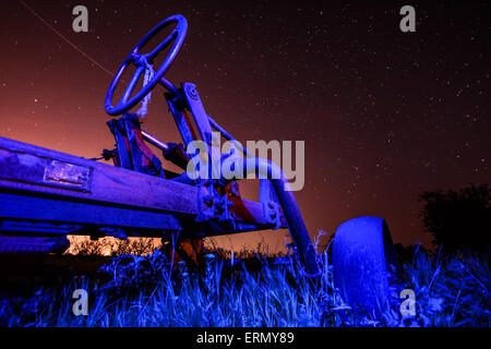 Eseguire del concetto di tempo - il vecchio trattore arrugginito sul cielo stellato sfondo Foto Stock