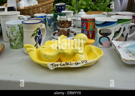 Set di carino Yellow egg calici in forma di anatre, in vendita presso un garage vendita con altre tazze e stoviglie. Foto Stock