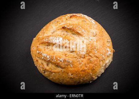 Intero rotolo di sesamo nero sulla scheda di ardesia isolato su uno sfondo bianco Foto Stock