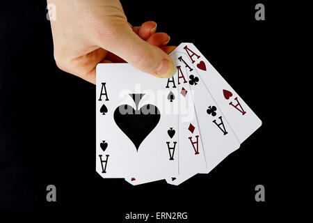 Croupier giocatore tenendo a portata di mano carta di credito asso di picche quattro di un tipo su sfondo nero Foto Stock