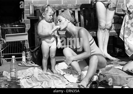 La madre e il bambino tenta di conservare al fresco a Birmingham lido durante la canicola estiva del 1976. Il 28 giugno 1976. Foto Stock