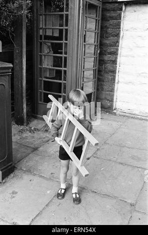 Cinque anni di Andrew Butler, completo con un mini-scala, telefoni la sua ragazza- sei anni Jayne Myers dalla casella telefono alla fine del suo viaggio. Il 6 settembre 1972. Foto Stock