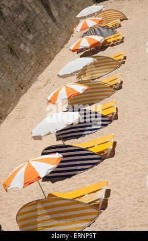 Lettini e ombrelloni sulla spiaggia di Algarve città di Armacao de Pera Portogallo meridionale Foto Stock