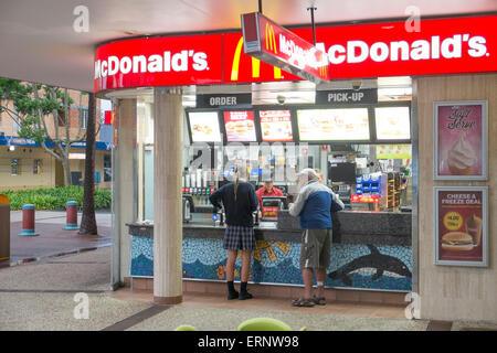 Uomo e una ragazza della scuola di ordinare un pasto da un Mcdonalds cafe in Port Macquarie, Nuovo Galles del Sud, Australia Foto Stock