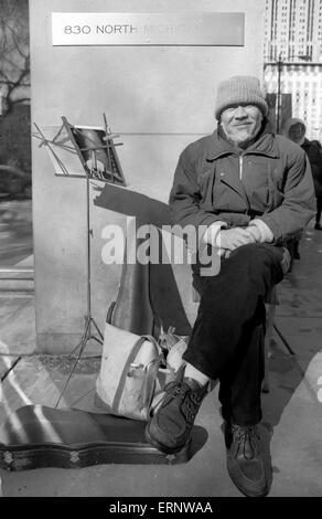 Chicago, IL, 22-Feb 1997: un musicista di strada prende un resto di North Michigan Ave. Foto Stock