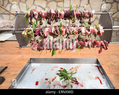 Gli uccelli allo spiedo con carne, pancetta e salvia pronti per la tostatura Foto Stock