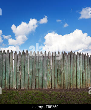 Vecchia staccionata in legno contro il cielo blu con nuvole. Sfondo per la progettazione Foto Stock