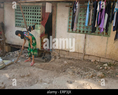 Donna musulmana cortile per la pulizia della casa in Boracay, Filippine Foto Stock