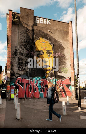 29 Maggio 2015 - Bristol, Regno Unito : inizio venerdì sera su Stokes Croft, un enorme street arte murale domina questa estremità della terrazza edificio Foto Stock