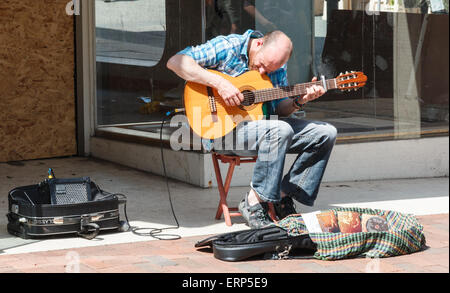 Busker di suonare una chitarra in un centro città , NEL REGNO UNITO , in una giornata di sole Foto Stock