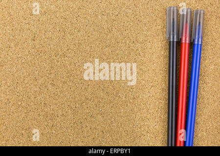 Tre marcatori di colore sulla bacheca di sughero Foto Stock