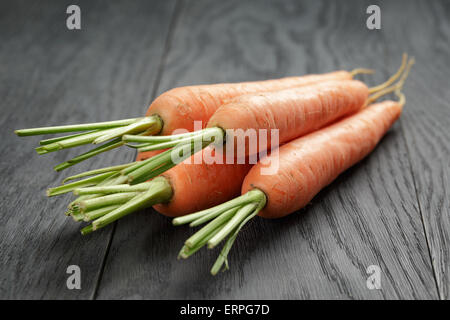 Le carote fresche sul vecchio tavolo in legno di quercia Foto Stock