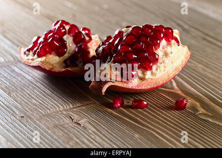 Mature melograno su un vecchio tavolo in legno Foto Stock