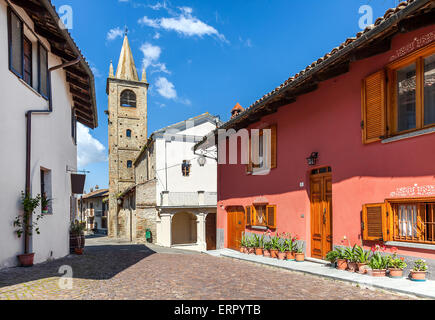 Stretta strada di ciottoli tra case tipiche e la vecchia chiesa abbandonata su sfondo nella piccola città italiana in Piemonte, Italia. Foto Stock