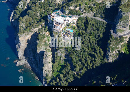 VISTA AEREA. Hotel di lusso arroccato su una scogliera sopra il mare. Grand Hotel Tritone, Praiano, Costiera Amalfitana. Provincia di Salerno, Campania, Italia. Foto Stock