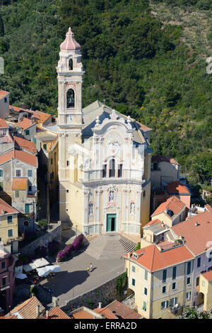 VISTA AEREA. Chiesa di San Giovanni Battista arroccata in cima al borgo medievale di Cervo. Provincia di Imperia, Liguria, Italia. Foto Stock