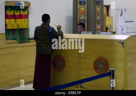 Un passeggero passa attraverso il banco di controllo dei passaporti all'interno della sala degli arrivi dell'aeroporto internazionale nella città di Paro in Bhutan Foto Stock