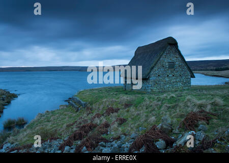 In blu la luce del tramonto, Scenic, vista pittoresca della storica restaurata ad alta Laithe Cruck Fienile - banche del serbatoio Grimwith, Yorkshire Dales, Inghilterra, Regno Unito. Foto Stock