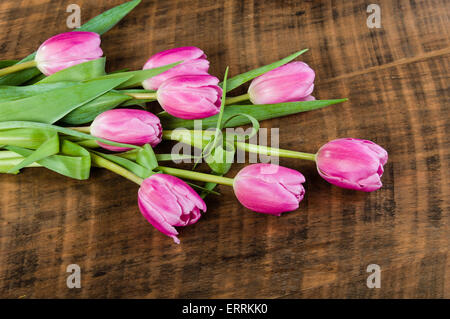 Fresh cut fascio di tulipani rosa su una tavola di legno Foto Stock