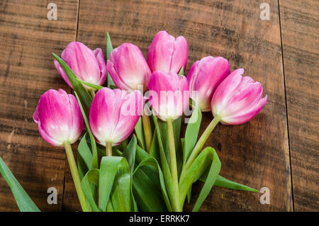 Fresh cut fascio di tulipani rosa su una tavola di legno Foto Stock