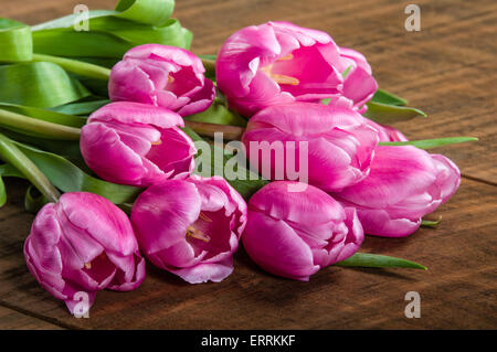 Fresh cut fascio di tulipani rosa su una tavola di legno Foto Stock