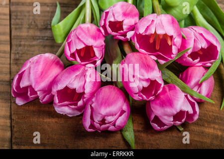 Fresh cut fascio di tulipani rosa su una tavola di legno Foto Stock