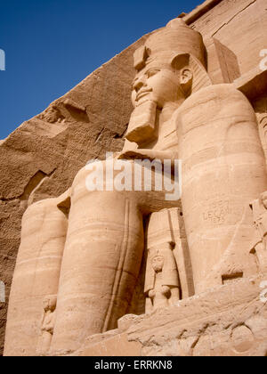 Uno dei quattro colossali 20 metro le statue del faraone Ramses II al di fuori del Grande Tempio di Abu Simbel in Nubia, Egitto Foto Stock