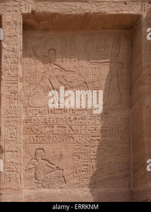 Sollievo al tempio di Abu Simbel raffigurante Ramses II tiene il suo nemico dai capelli mentre il dio Amon lo offre un'arma Foto Stock
