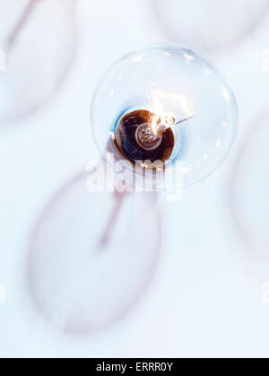 Di tungsteno incandescente lampadina con un'ombra su fondo azzurro Foto Stock