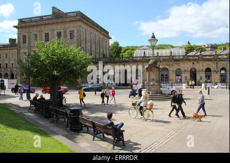 Le persone passano dai bagni termali e Cavendish Arcade sulla mezzaluna in Buxton, Derbyshire in un giorno caldo e soleggiato, England Regno Unito Foto Stock