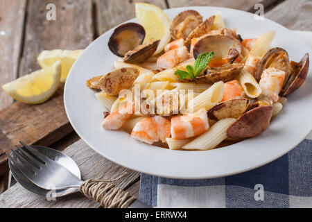 Maccheroni con gamberi e vongole in stile di pesce sulla piastra bianca Foto Stock