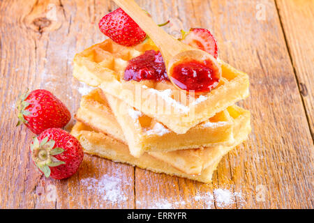 Waffles fatti in casa con fragole sciroppo di acero su sfondo di legno Foto Stock