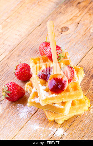 Waffles fatti in casa con fragole sciroppo di acero su sfondo di legno Foto Stock