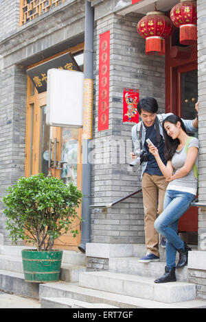 Felice coppia giovane azienda smart phone e fotocamera Foto Stock