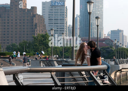 Un paio di turisti baciare in Bund. Cina l'amore. Il Bund promenade, Shanghai, Cina. Cina Shanghai turistiche skyline di Shanghai Foto Stock