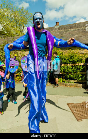 Stilt walker in parata a mano Hebden Bridge West Yorkshire England Regno Unito Regno Unito Foto Stock