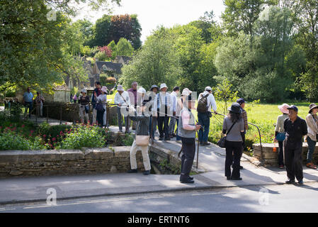 Turisti asiatici a Bibury, Cotswolds, Gloucestershire, Inghilterra Foto Stock