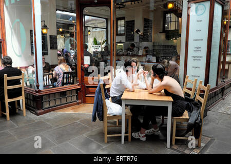 I giovani alla moda giovane seduto fuori " il piano " caffè davanti alla Spillers record in Morgan Arcade Cardiff Wales UK KATHY DEWITT Foto Stock