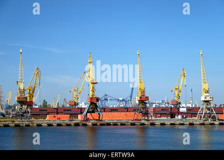 Vista sul porto commerciale con gru, contenitori e carichi Foto Stock