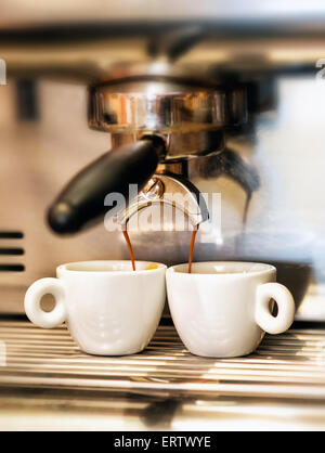 Macchina per caffè l'erogazione di un doppio espresso italiano in due piccole coppe Foto Stock