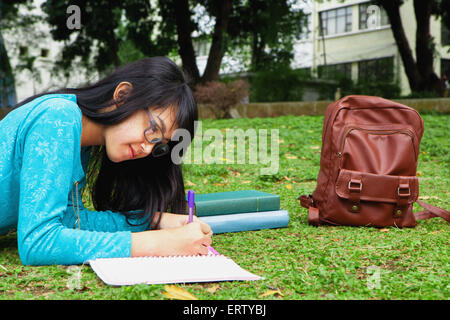 Uno studente universitario iscritto home lavorare all'aperto in università Foto Stock