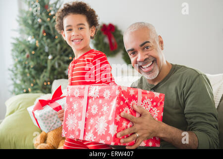 Razza mista nonno e nipote di aprire i regali di Natale Foto Stock