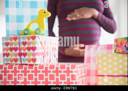 Nero donna incinta ammirando doni al bambino, doccia Foto Stock