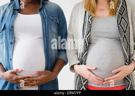 Close up di donne in stato di gravidanza tenendo gli stomaci Foto Stock